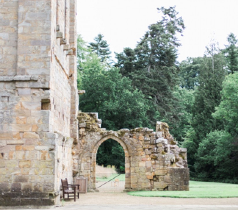 An archway that is attached to an large old building