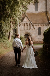 bride and groom walking to a priory wedding at Brinkburn Northumberland